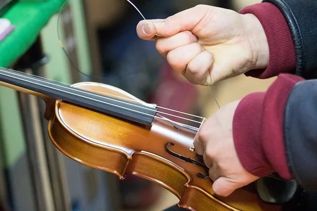 Imagen de persona cambiando cuerda rota a un violin